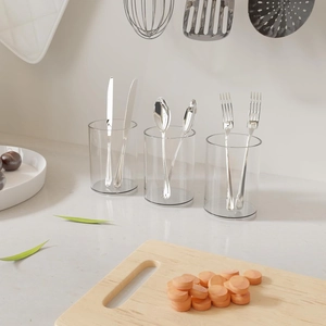 Polished stainless steel cutlery set with spoons and forks in clear acrylic holders