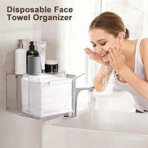 Clear acrylic wall-mounted holder for disposable face towels with a top storage tray