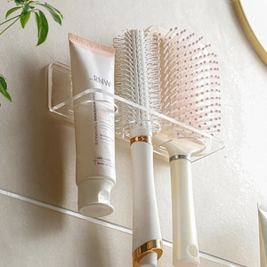 Wall-mounted acrylic bathroom organizer with slots for toothbrush and comb storage