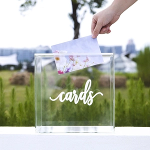 Detailed view of transparent acrylic card box with white cards script on outdoor lawn