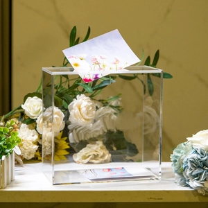 Macro shot of the clear acrylic box slot with floral cards for wedding card collection