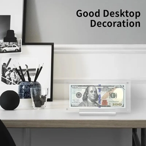 Detailed view of acrylic dollar display block with gold foil banknote on a desk stand