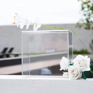 Outdoor close-up of clear acrylic card box with lid slot for wedding decor and events