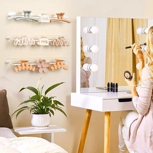 Three-piece clear acrylic wall-mounted hair claw clip organizers in a bedroom setting