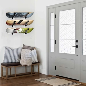 Modern 3-tier black wall-mounted skateboard rack displaying three boards in a cozy room