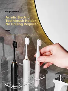 Detail of wall-mounted acrylic toothbrush holder with three slots on marble wall