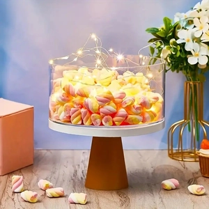 Close-up of clear acrylic cake stand with LED lights and colorful marshmallows