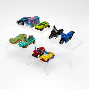 Close-up of polished clear acrylic U-shaped display risers for toys and cupcakes