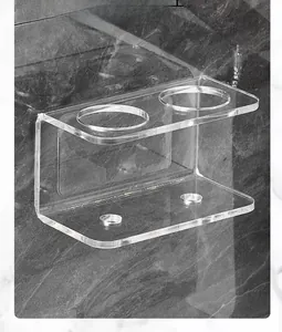 Macro detail of clear acrylic wall mount holder for electric toothbrushes on marble wall