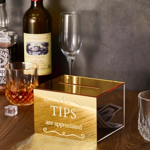 Boîte à pourboires en acrylique doré avec texte décoratif dans un bar chic