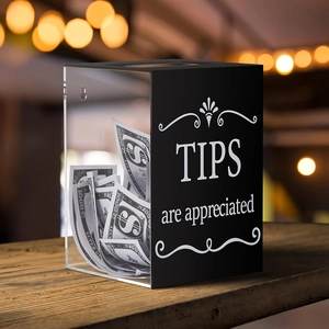 Detail of acrylic tip box with 'TIPS are appreciated' text and wall mount holes on wood