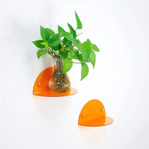 Set of 2 orange acrylic floating shelves for wall decor showcasing plants and toys