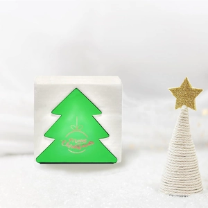 Christmas tree shaped napkin holder with Merry Christmas greeting on a snowy background