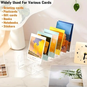 Close-up of 6-slot clear acrylic greeting card display stand on marble desk