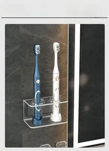 Detail of transparent acrylic wall-mount holder for two electric toothbrushes on marble