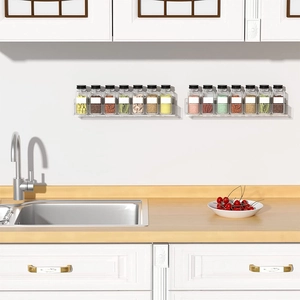 Detail of two clear acrylic wall shelves organizing spice jars in a modern kitchen