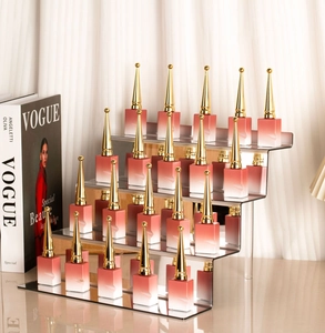 Macro detail of luxury lipsticks with gold tapered caps on a clear acrylic tiered riser