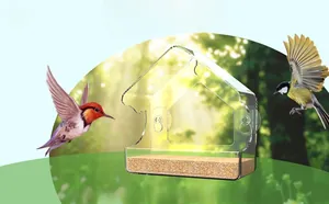 Macro view of clear acrylic bird feeder with three suction cups and grain on wood