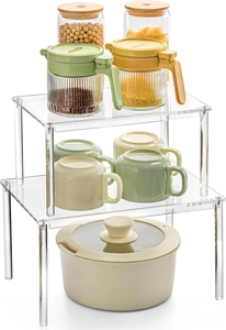 Clear acrylic tiered kitchen cabinet organizers showing tiered spice and jar storage