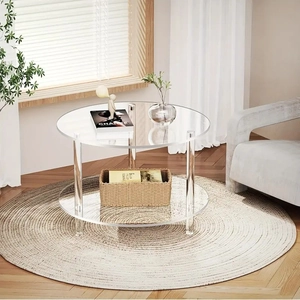 Detail of clear double-layer acrylic round coffee table with sleek three-pillar support