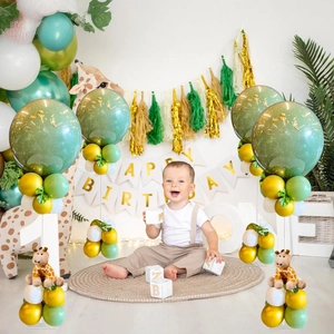 Forest theme birthday decor with olive green balloons and giraffe toy centerpiece