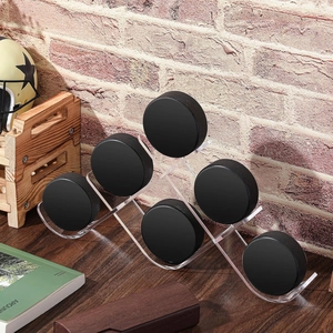 Tiered acrylic hockey puck display stand holding six pucks on a dark wood table
