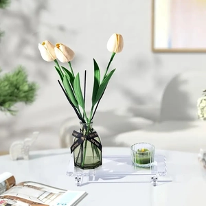 Clear acrylic bathroom tray with green glass vase, tulips and a scented candle for home decor