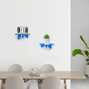Modern blue drip acrylic floating wall shelf displaying a desk calendar on a white wall
