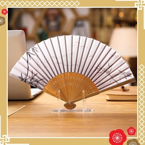 Transparent acrylic fan stand displaying a traditional bamboo folding fan on a wooden desk