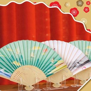 Detailed view of folding fans with crane patterns on clear acrylic display stands