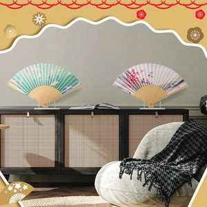 Detailed view of folding fans with crane patterns on clear acrylic display stands