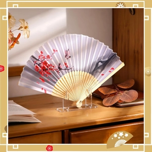 Detail of a floral fan on a transparent acrylic stand with autumn decor on a wooden desk