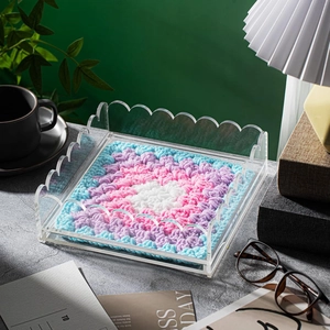Clear wavy acrylic tray featuring a colorful hand-crocheted floral mat for desktop decor