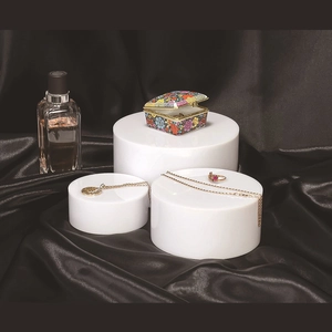 Set of three white acrylic cylindrical display risers for jewelry and cosmetics showcasing