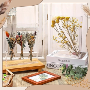 Close-up of clear acrylic display box with dried flower bouquets and wooden base