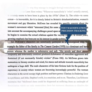 Macro view of clear acrylic bar magnifier with blue guide line on text page