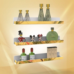 Detail of white wall-mounted U-shaped shelves with gold floral trim for perfume storage