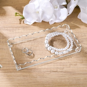 Close-up of wavy transparent acrylic tray showing jewelry with elegant scalloped edges