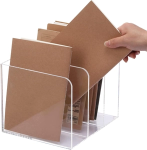 Close-up of a 3-slot transparent acrylic magazine rack with notebooks on white background