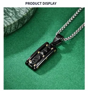 Macro detail of punk style pyramid pendant with black texture and golden rivets decoration