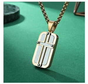 Detail view of gold cross pendant with silver brushed texture inlay and box chain