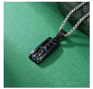 Macro shot of men's industrial box chain with a black textured rectangle pendant