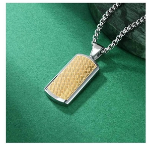 Detail of silver stainless steel rectangular pendant with golden woven texture and box chain