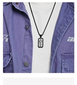Close-up of cross rectangle pendant necklace worn on purple washed denim shirt