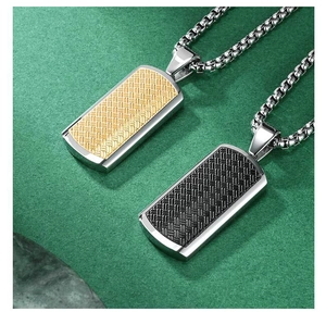 Detail of dog tag pendants with woven texture in gold and black on a dark matte surface