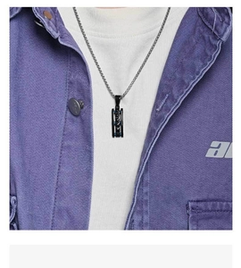 Close-up of black rectangular pendant with blue inlay on a silver chain necklace