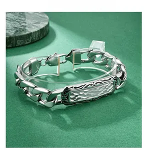 Macro detail of men's chunky stainless steel chain bracelet with embossed plaque
