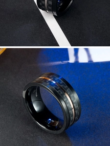 Détail macro d'une bague pour homme en acier noir avec carbone et insert en or rose