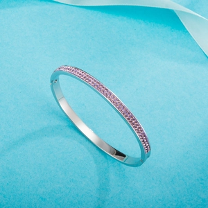 Silver stainless steel hinge bangle with double rows of purple crystals on blue background