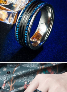 Détail de la bague en acier inoxydable avec bande noire et texture d'engrenage bleu vif